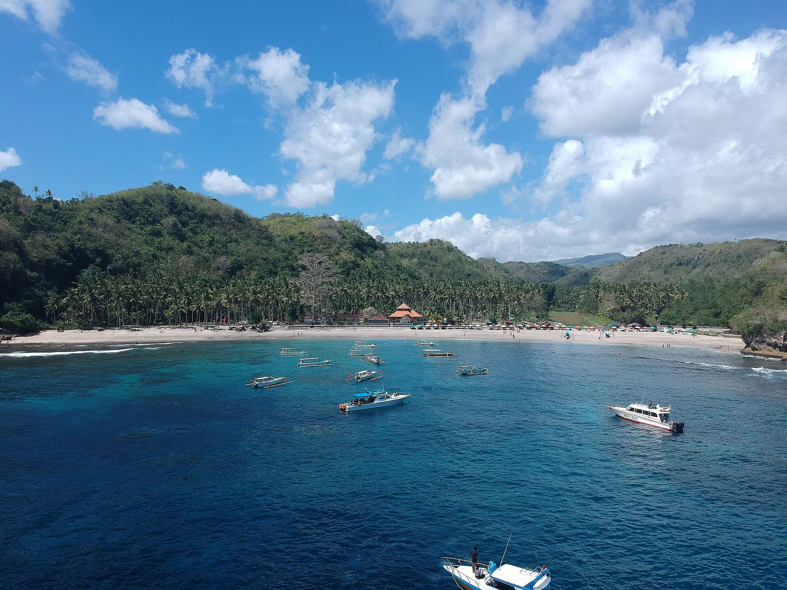 Boats anchored in the clear blue water of Crystal Bay, Nusa Penida