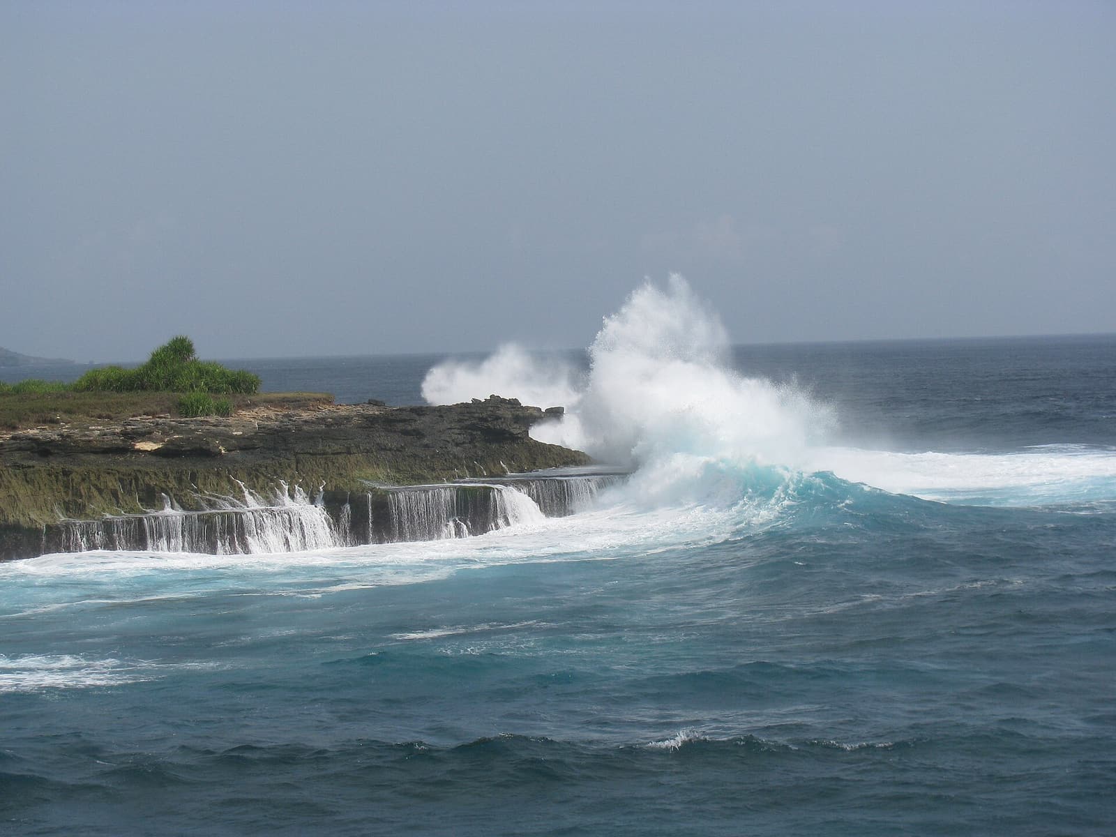 A wave exploding into white spray against the rocks at Devil’s Tear